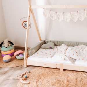 Bodenbett mit Bettschlange und kuscheliger Bettwäsche