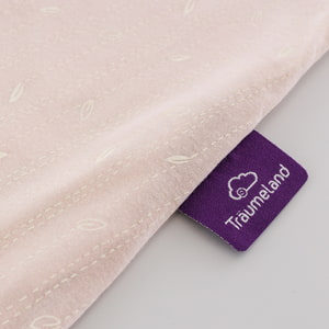 Schlafsack nach GOTS zertifiziert im Design Blätter beige Detailfoto vom eingenähten lila Träumeland-Etikett