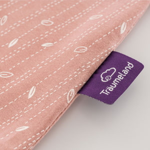 Schlafsack nach GOTS zertifiziert im Design Blätter rosa Detailfoto vom eingenähten lila Träumeland-Etikett