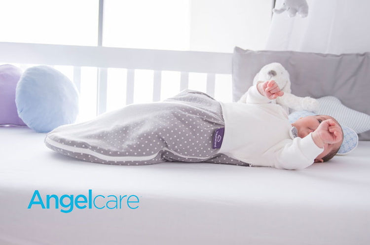 Baby im Babybett mit Angelcare-Logo Baby im Babybett mit Angelcare-Logo
