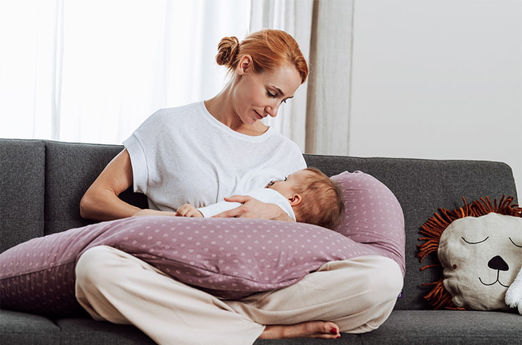 mama-mit-stillkissen-beim-stillen