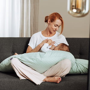 Mother with baby while nursing on the couch