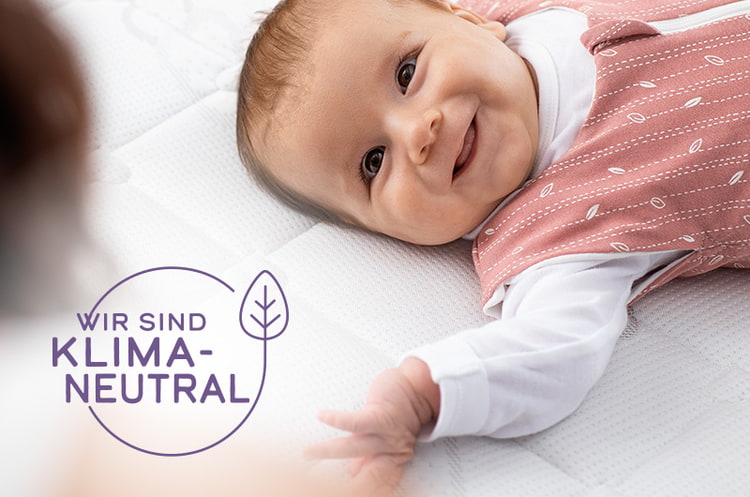 Baby auf nachhaltiger Babymatratze in einem nach GOTS zertifizierten Schlafsack