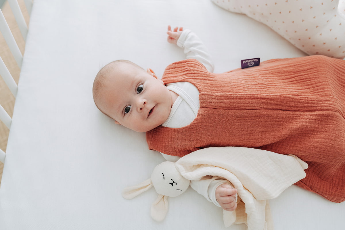 Baby im Sommer mit Sommerschlafsack Baby mit Sommerschlafsack im Bett