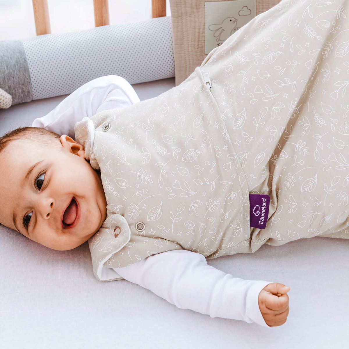 Baby with cuddly pillow and sleeping bag
